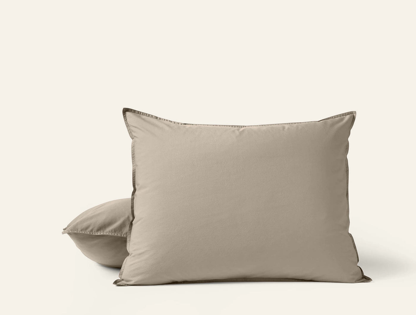 Close-up of two stacked taupe Coyuchi Crinkled Percale pillowcases with tonal stitched edges.
