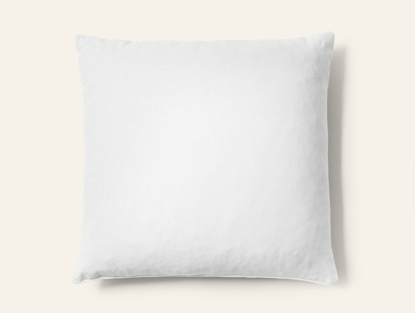 Coyuchi shredded latex pillow in white, square shape on light grey background.