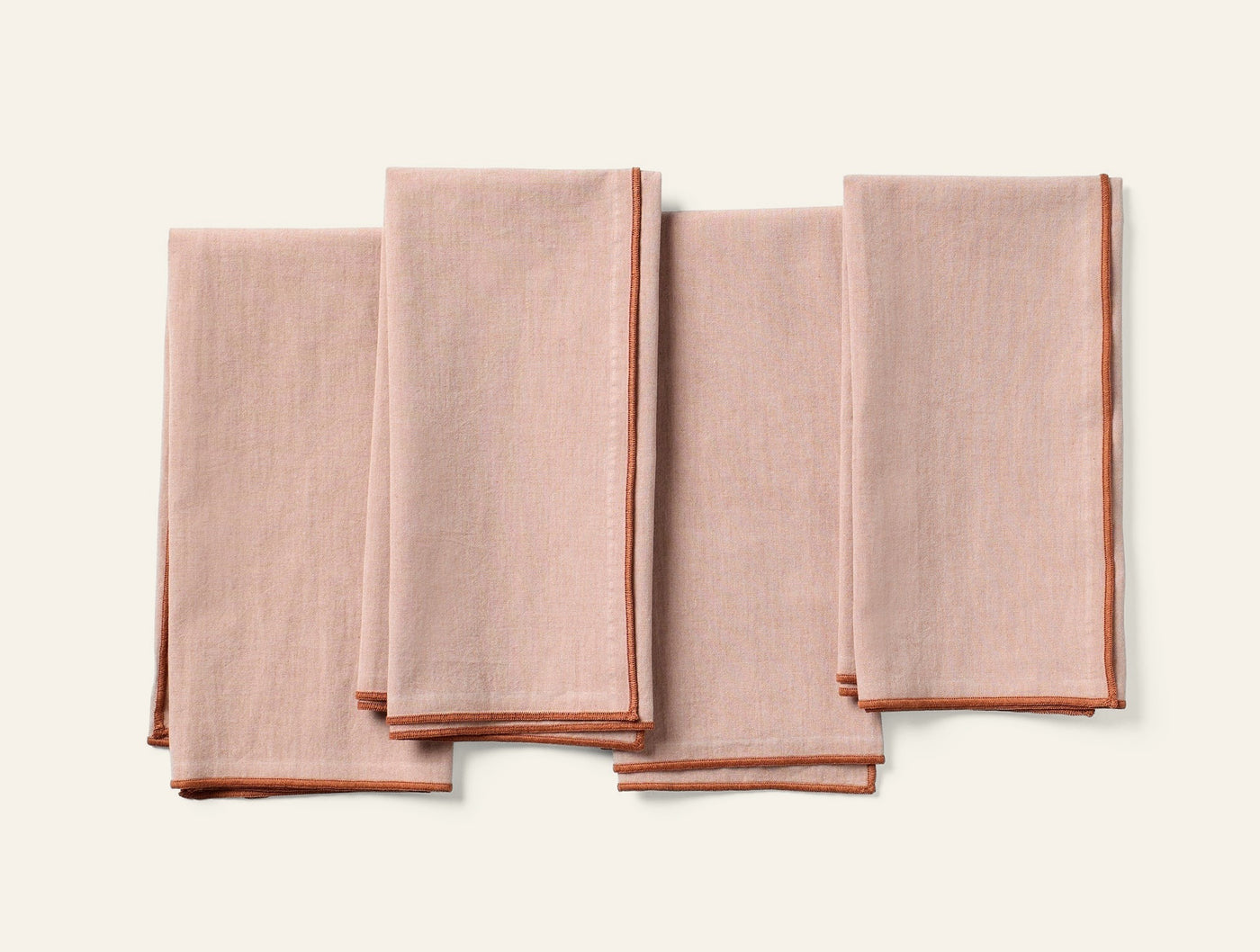 Coyuchi Print Percale napkin set of four in blush with terracotta border trim.