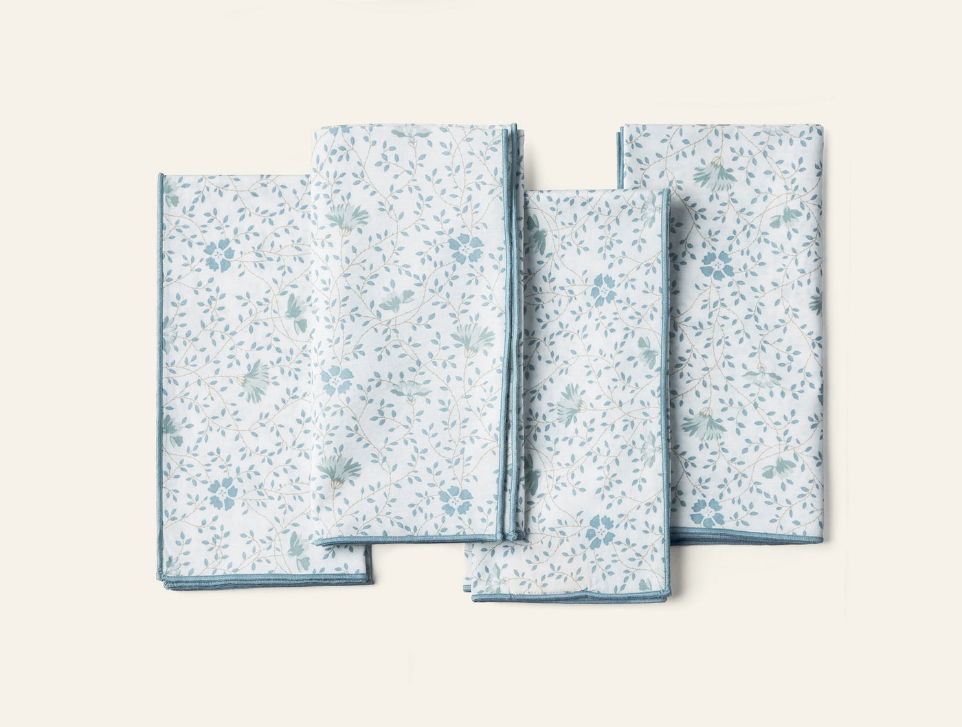 Coyuchi Print Percale napkin set, sky blue floral pattern on white, four napkins fanned flat.