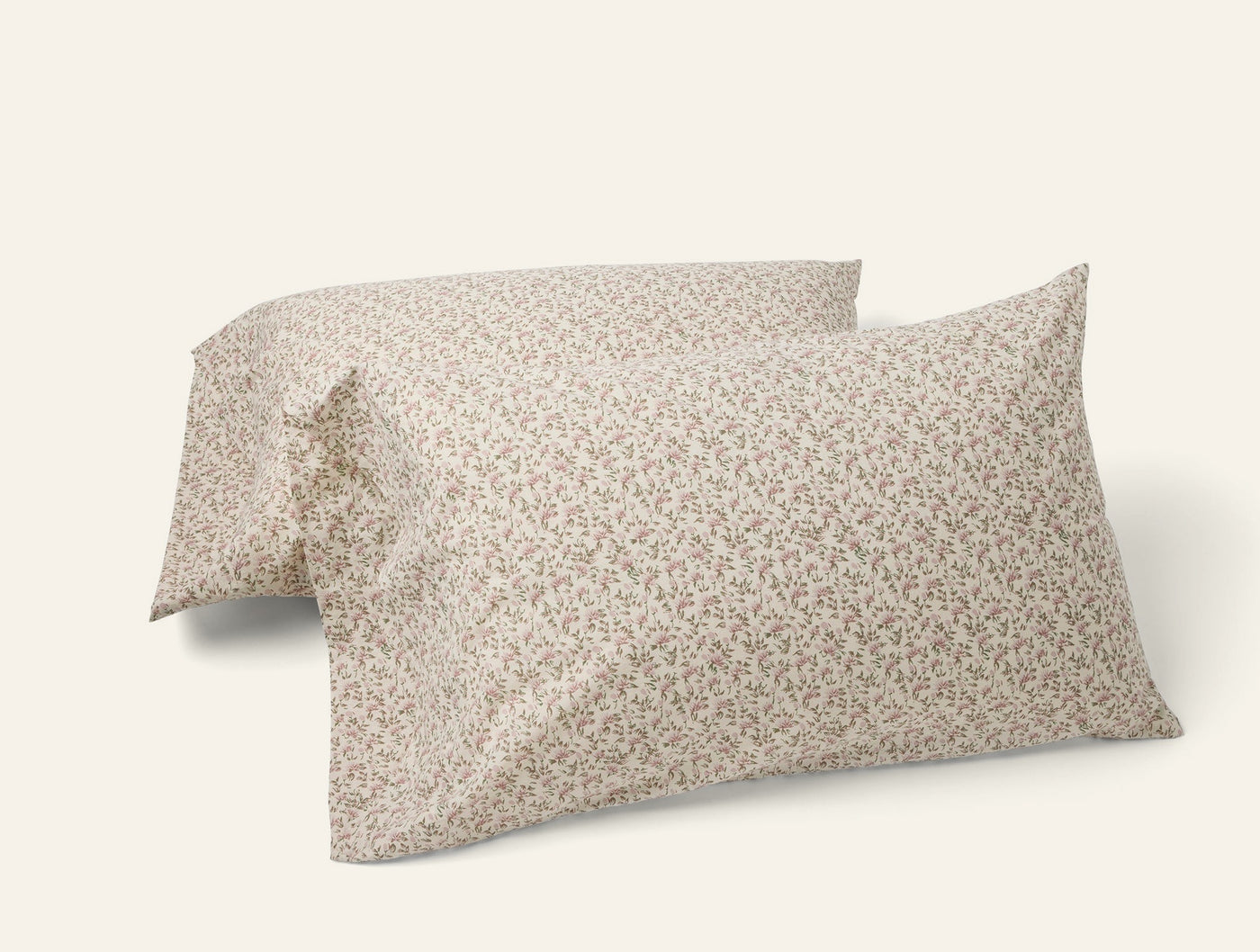 Two Coyuchi percale pillowcases with delicate ditsy floral print in warm taupe tones.