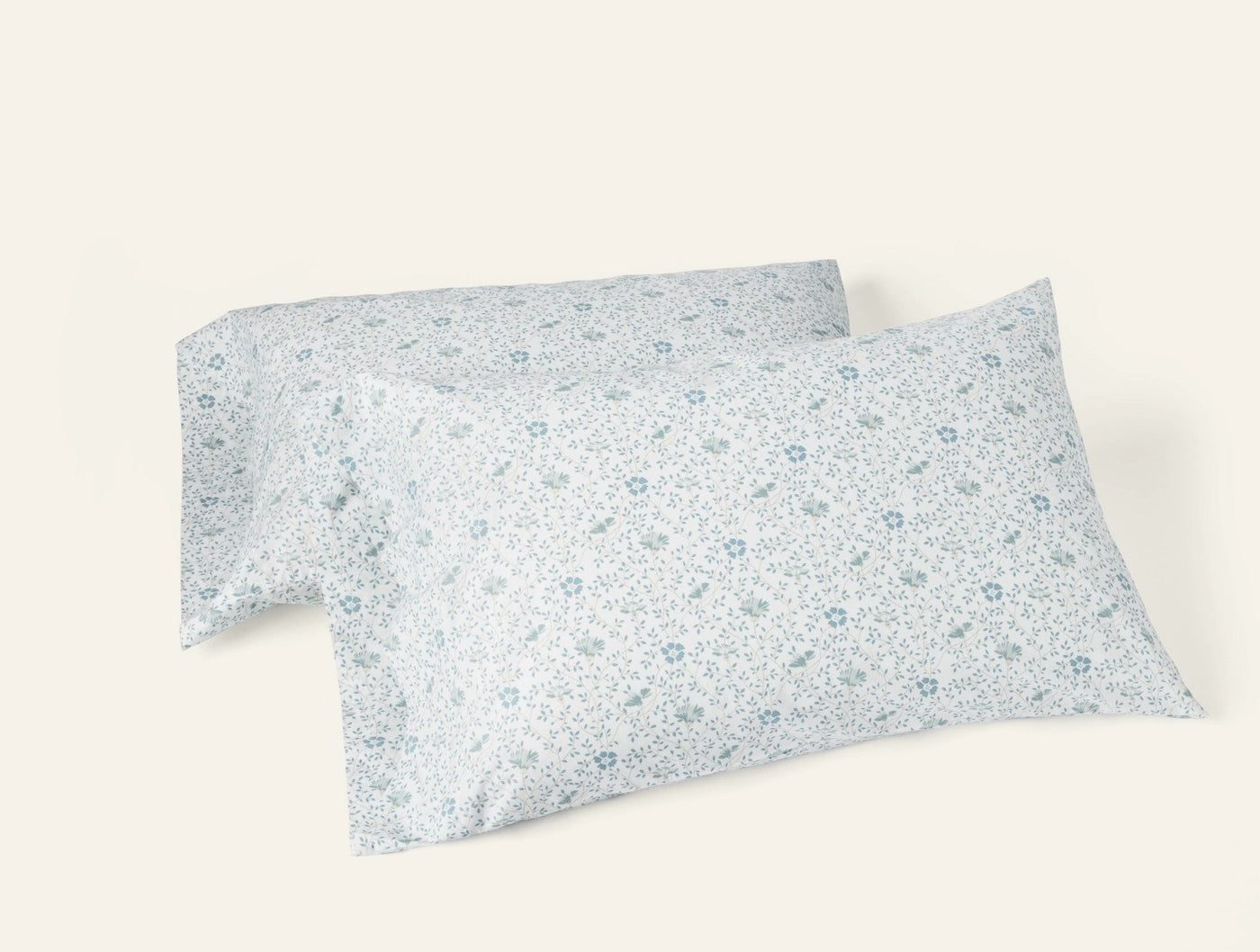 Two white percale pillowcases with delicate blue floral print, stacked at an angle.