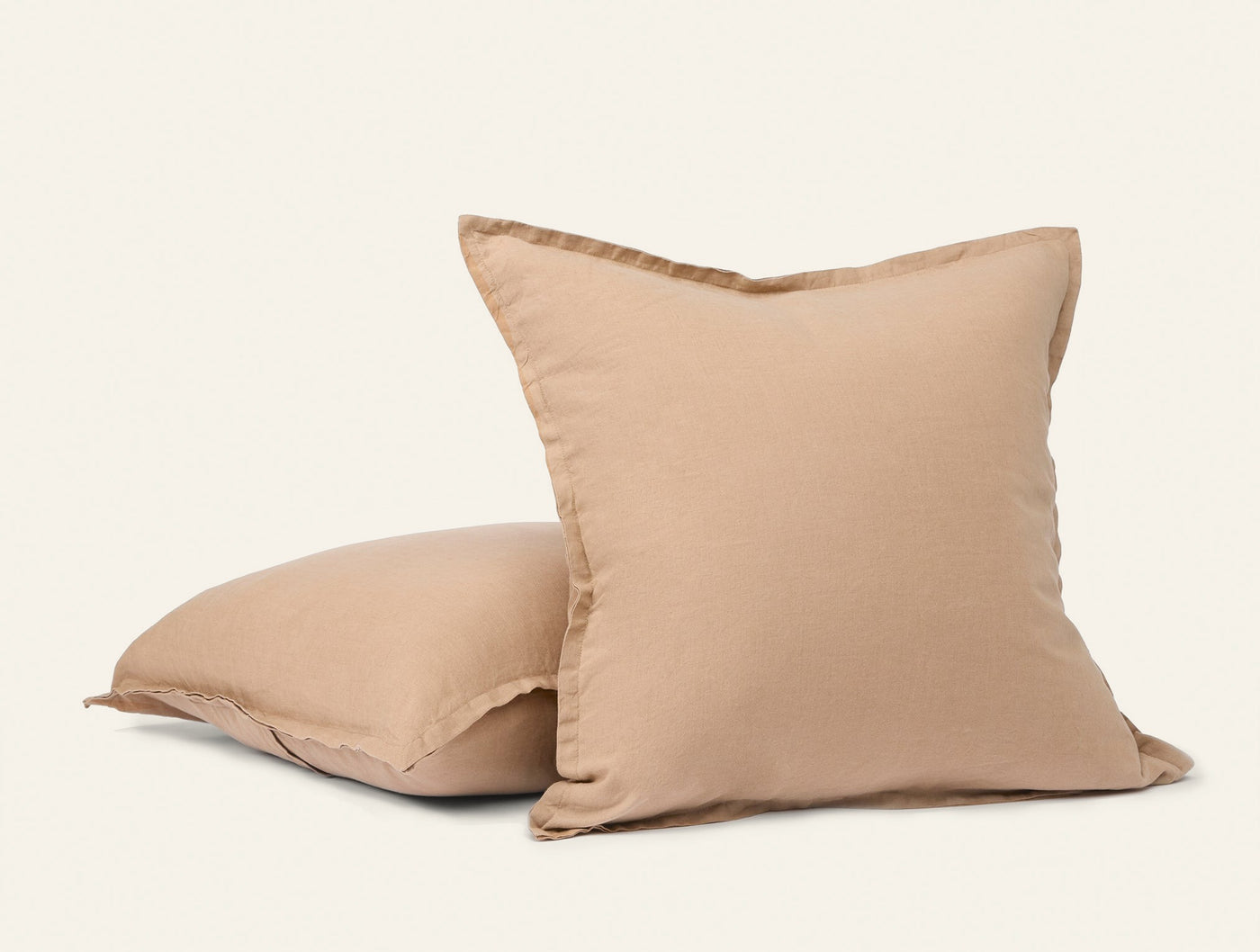 Two Coyuchi Relaxed Linen decorative pillows in warm sand, showing flanged edge detail.