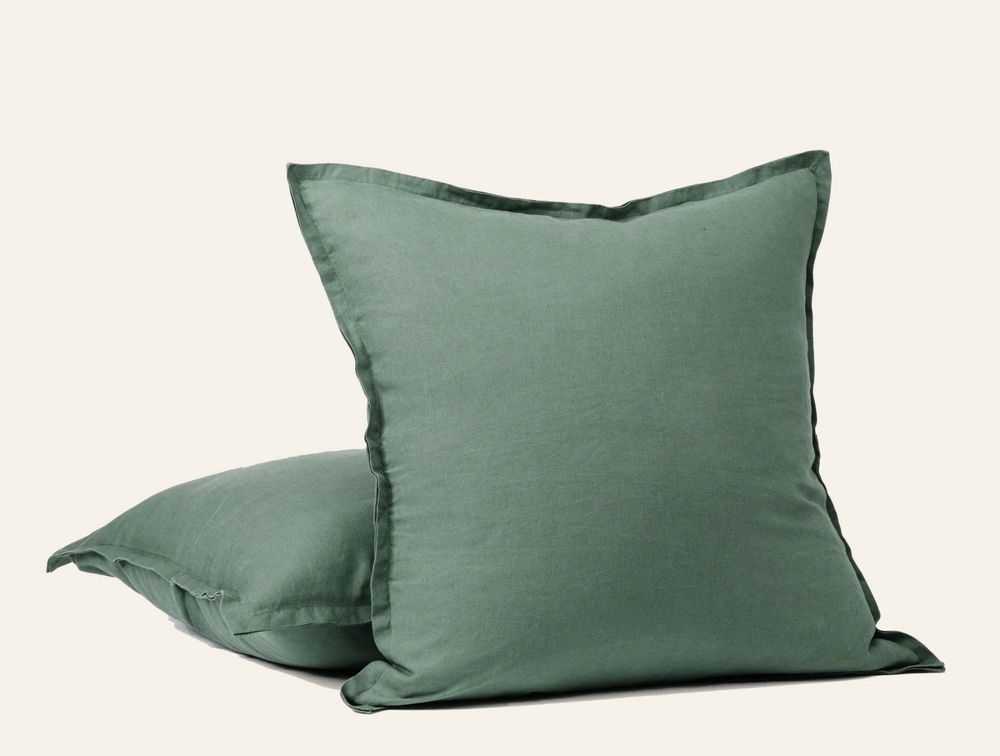 Coyuchi Relaxed Linen decorative pillow covers in sage green, stacked pair with flanged edges.