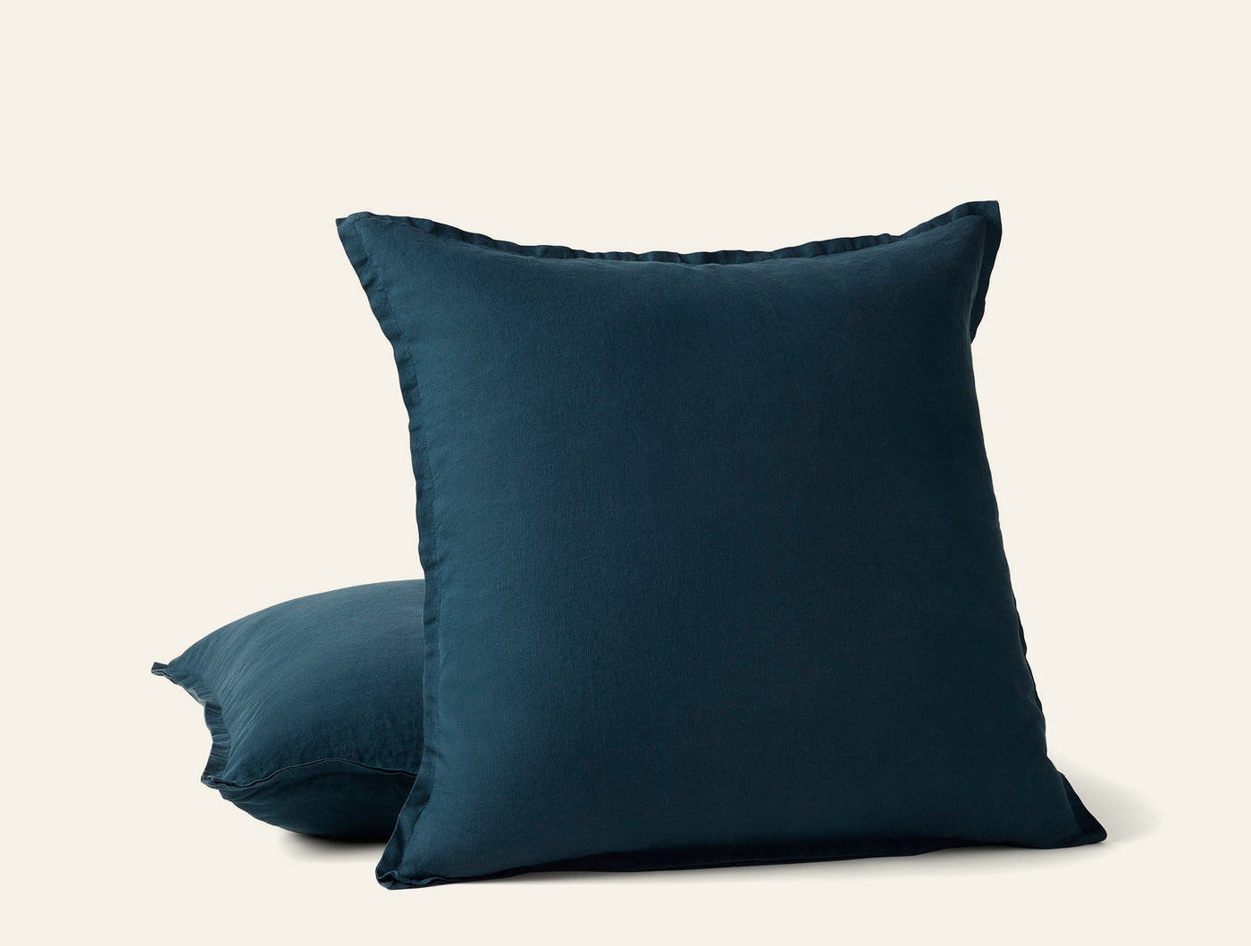 Coyuchi Relaxed Linen pillow covers in deep teal, two stacked, showing frayed edge trim.