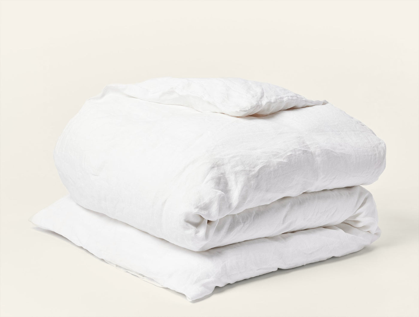 Coyuchi Relaxed Linen duvet cover in white, neatly folded showing soft, crinkled linen texture.