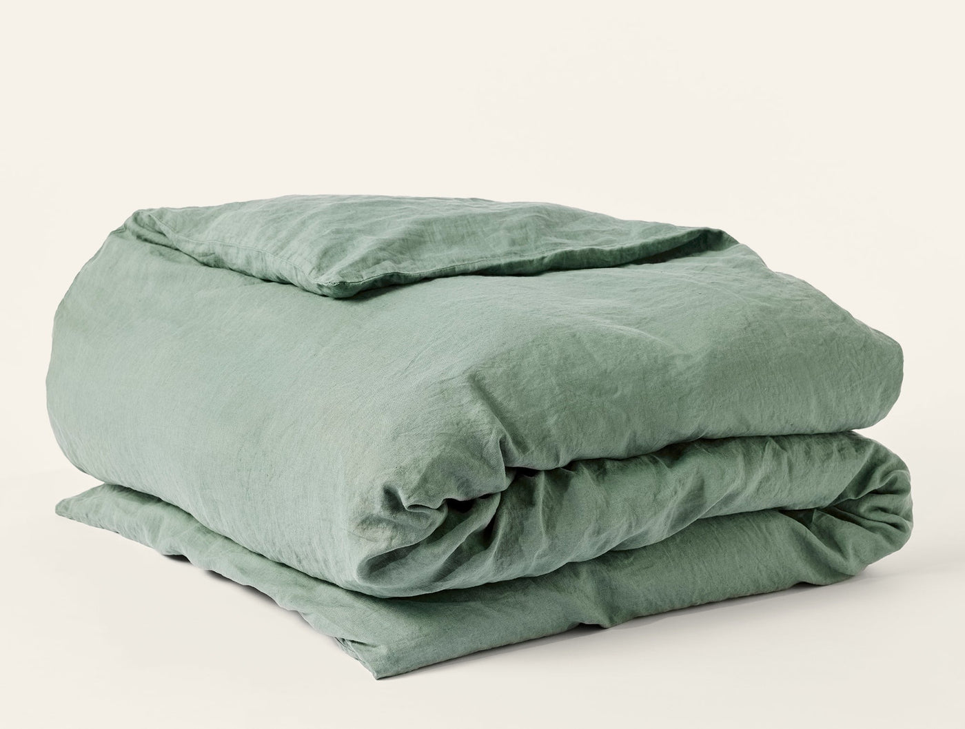Coyuchi Relaxed Linen duvet cover folded, showing sage green washed linen texture.