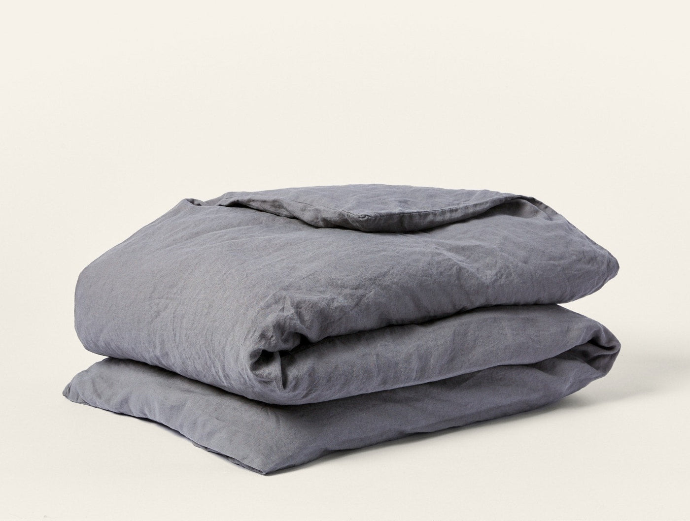 Folded slate Coyuchi Relaxed Linen duvet cover showing natural wrinkled texture.
