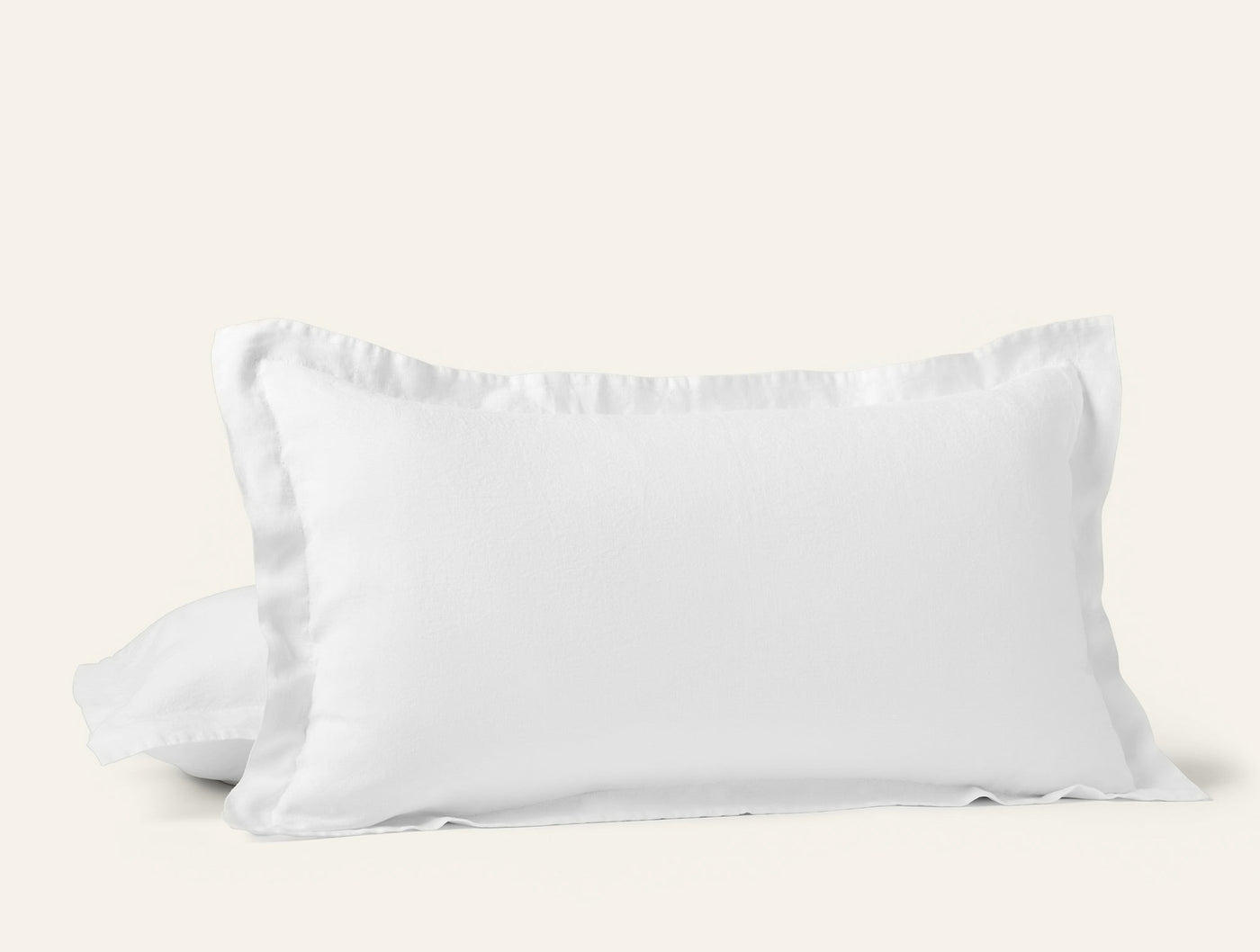 Coyuchi Relaxed Linen pillow sham in white with ruffled edge trim, softly draped.