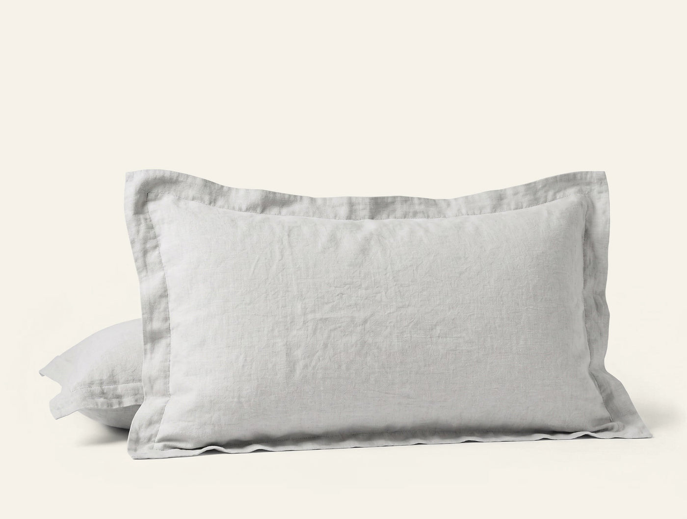Pair of white Coyuchi Relaxed Linen pillow shams stacked, showing flange edge detail.