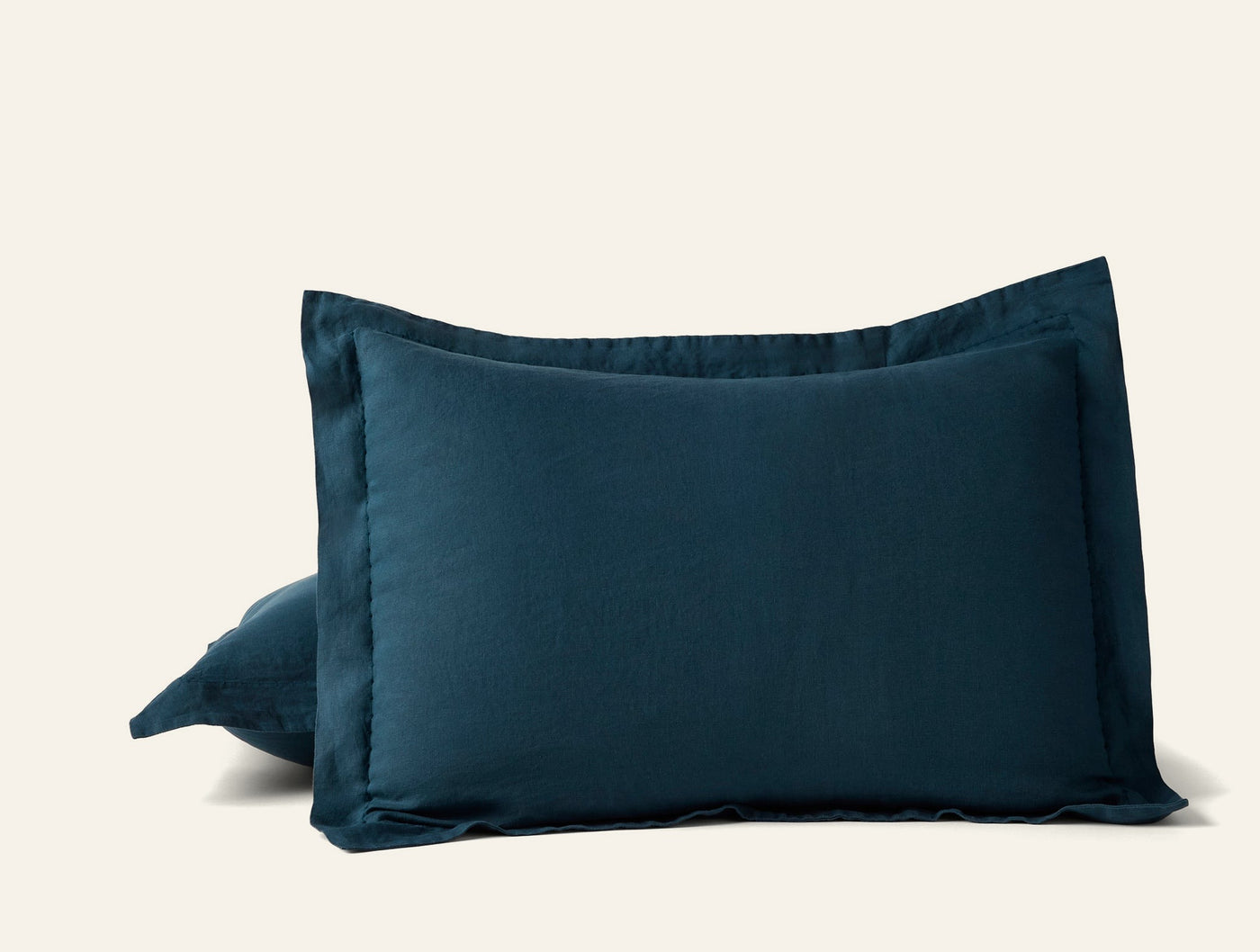 Pair of Coyuchi Relaxed Linen shams in deep teal, showing flange edge detail.