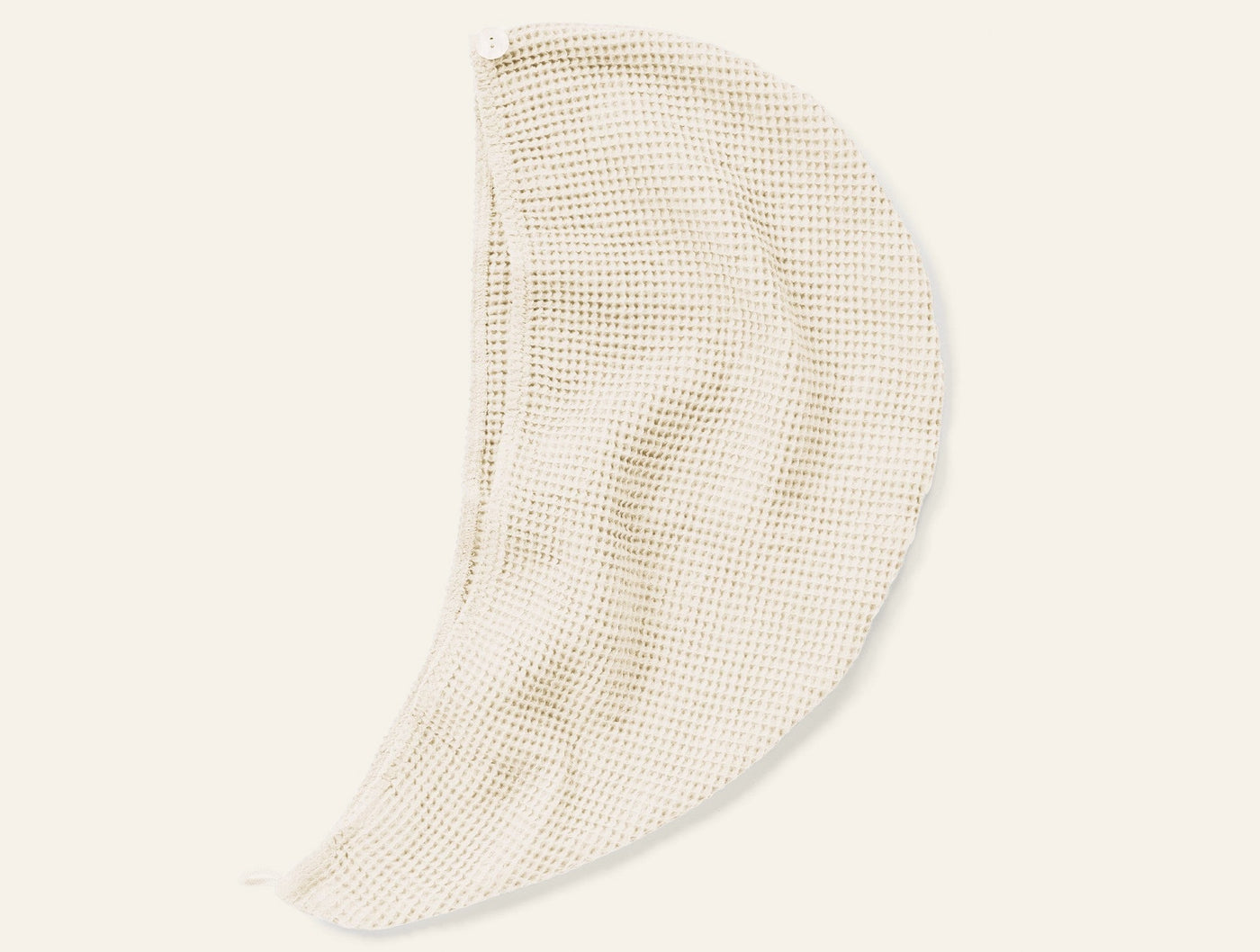 Close-up of Coyuchi Waffle hair wrap in natural, showing open-weave waffle texture and draped form.