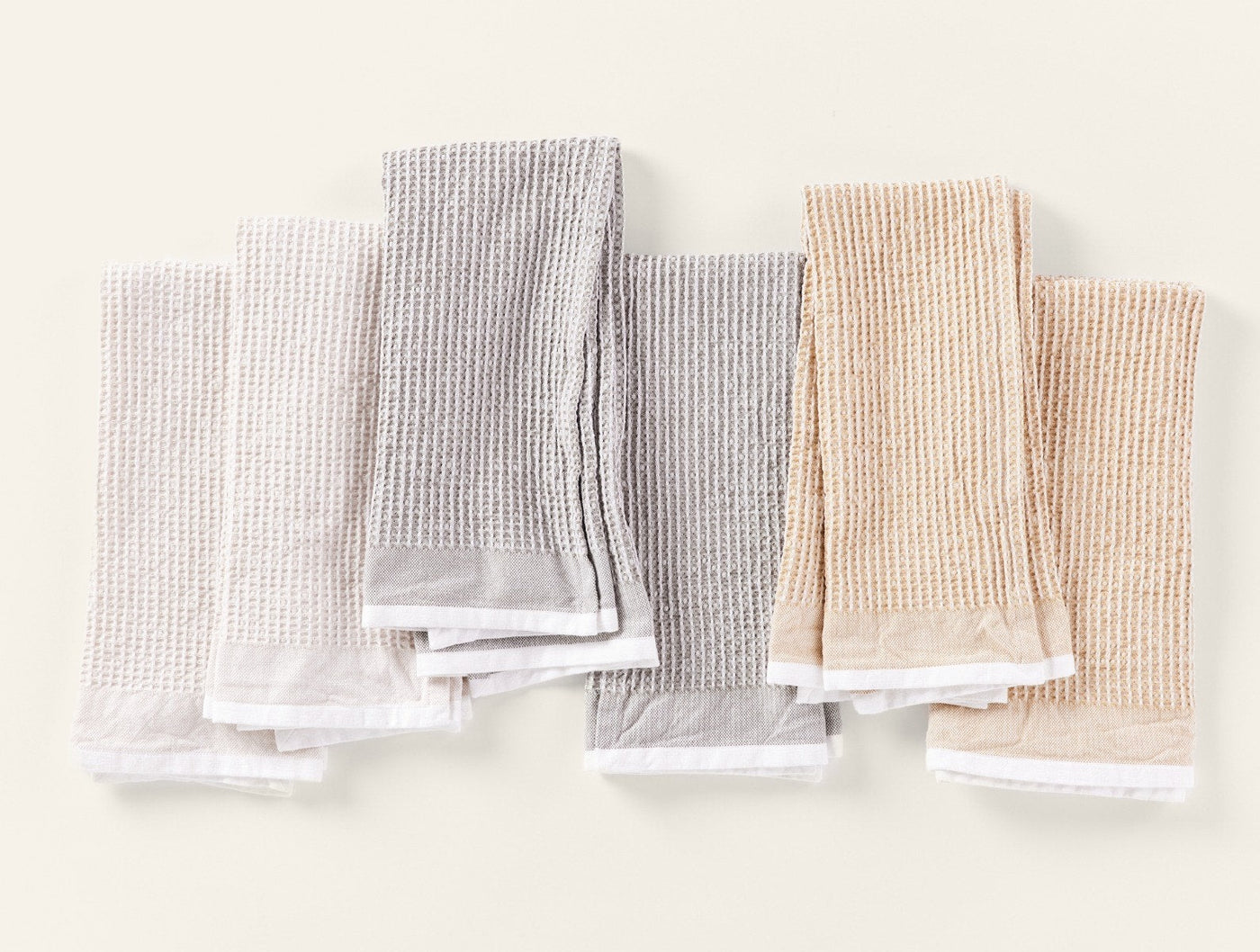 Coyuchi Waffle kitchen towels in grey and sand, flat lay showing set of six.