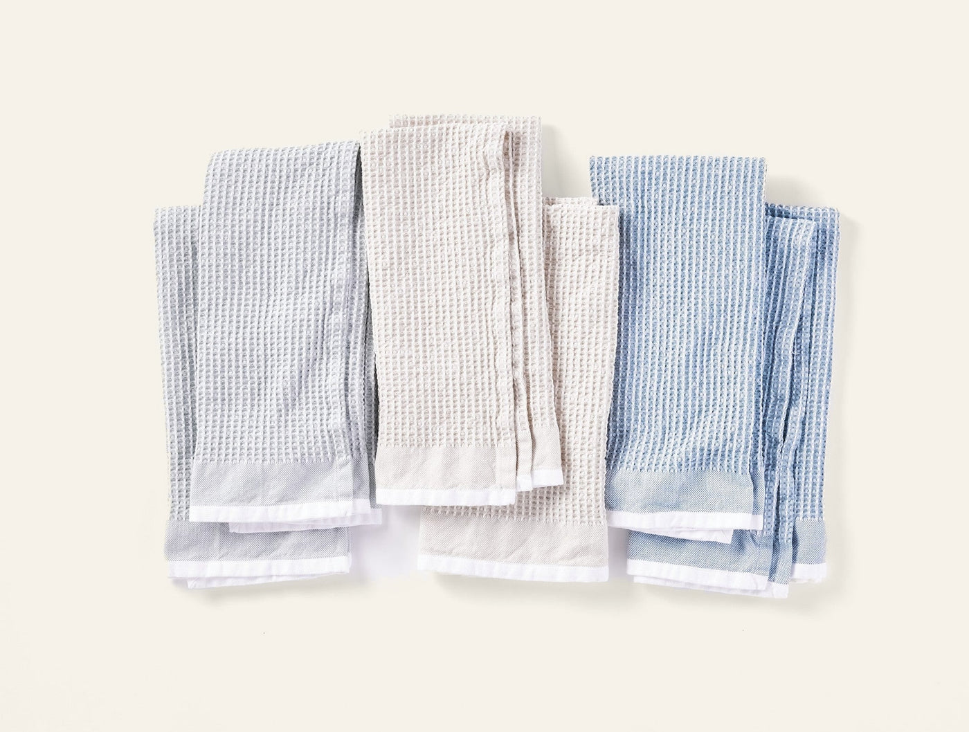 Coyuchi Waffle kitchen towels in fog and natural, flat lay showing all six folded towels.