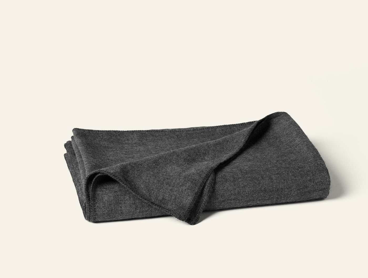 Coyuchi Pacaya Baby Alpaca blanket folded, charcoal heathered knit texture visible.