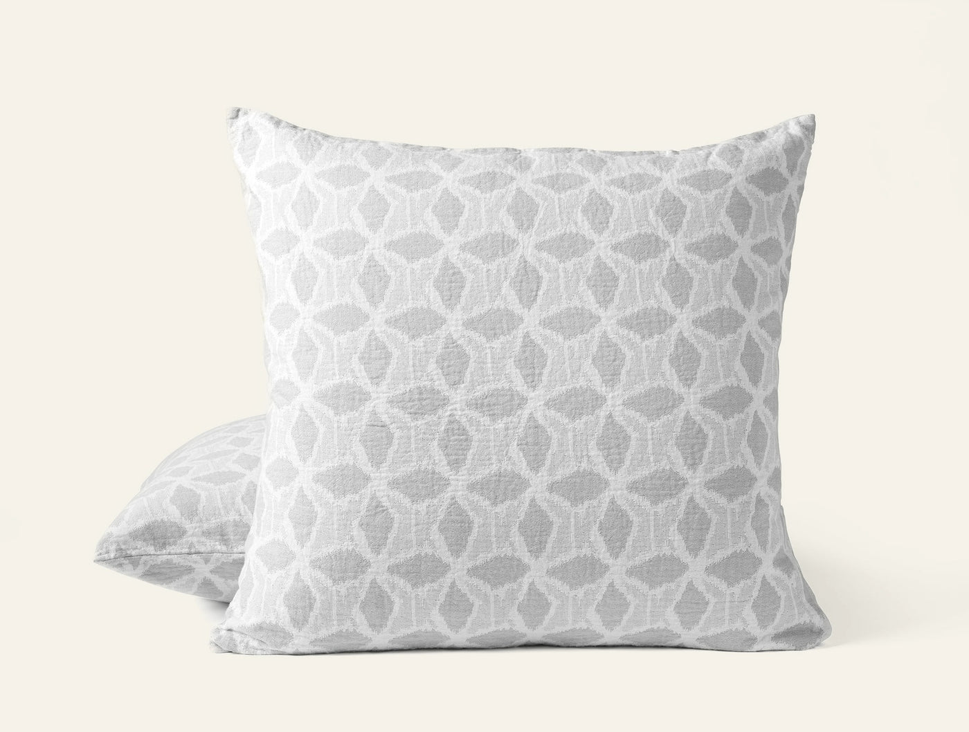 Front and back view of Coyuchi Palomar sham in silver geometric ikat pattern on white.