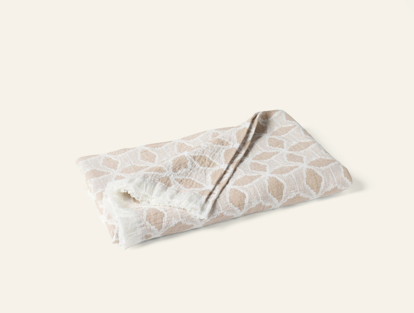 Coyuchi Palomar throw folded, ivory and sand geometric pattern on textured cotton.