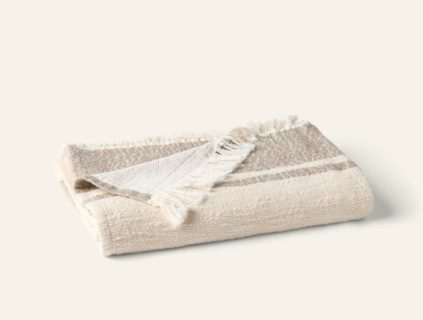 Coyuchi Pampas throw folded in ivory with taupe stripes and fringe trim.