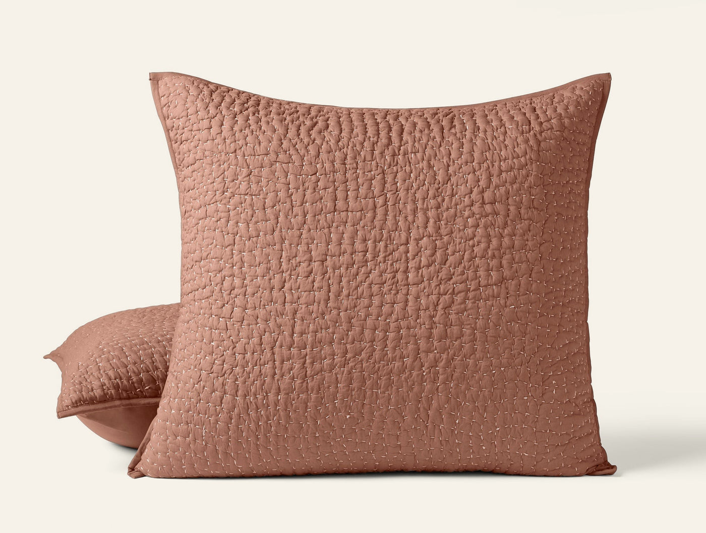 Close-up of two terracotta Coyuchi Pebbled Handstitched shams showing quilted texture detail.