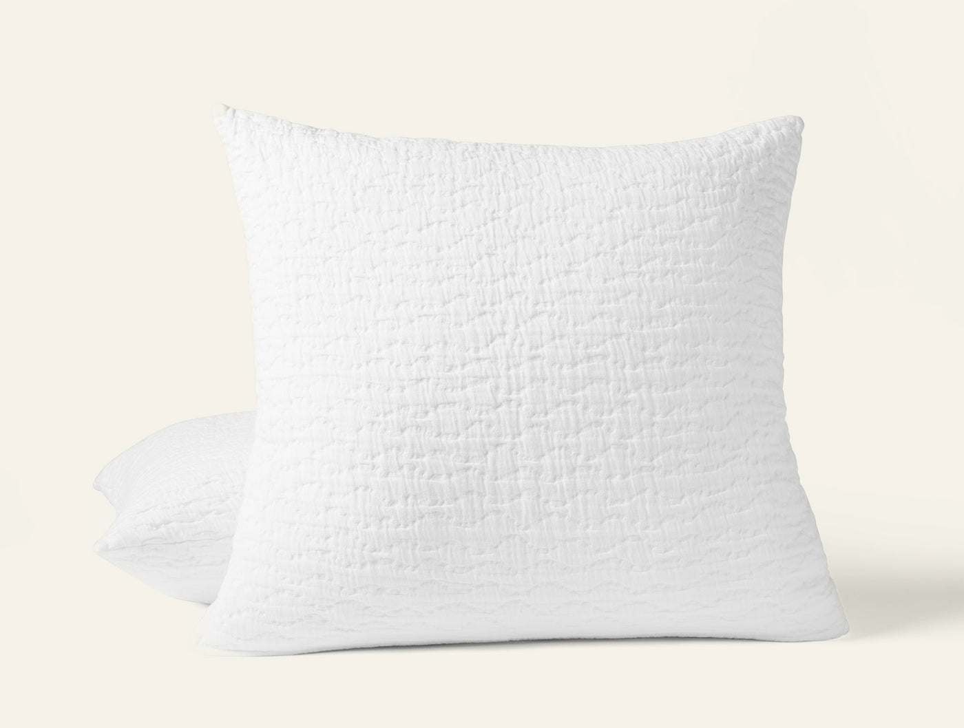 Coyuchi Pescadero Matelassé sham in white with textured woven surface, propped upright.