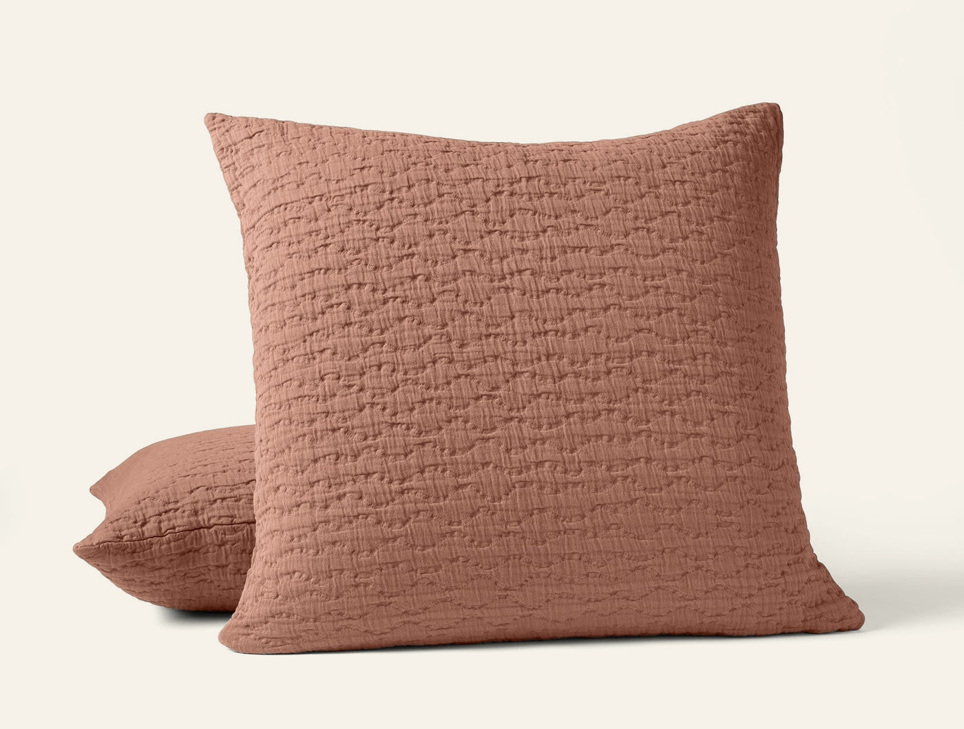 Terracotta matelassé pillow sham with quilted texture, shown front and side angled view.