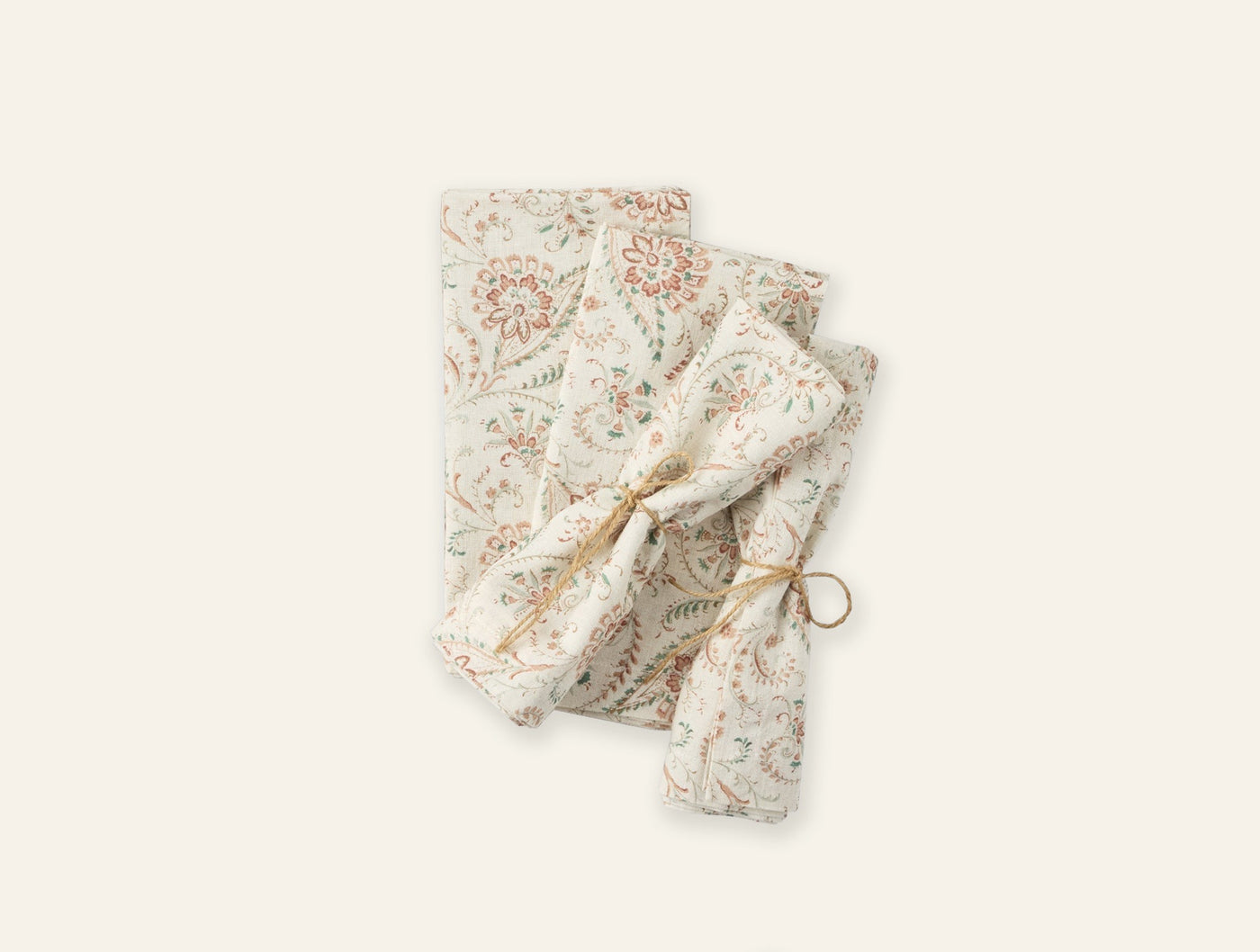 Close-up of folded Coyuchi Ponderosa Print napkins with botanical floral pattern, tied with twine.