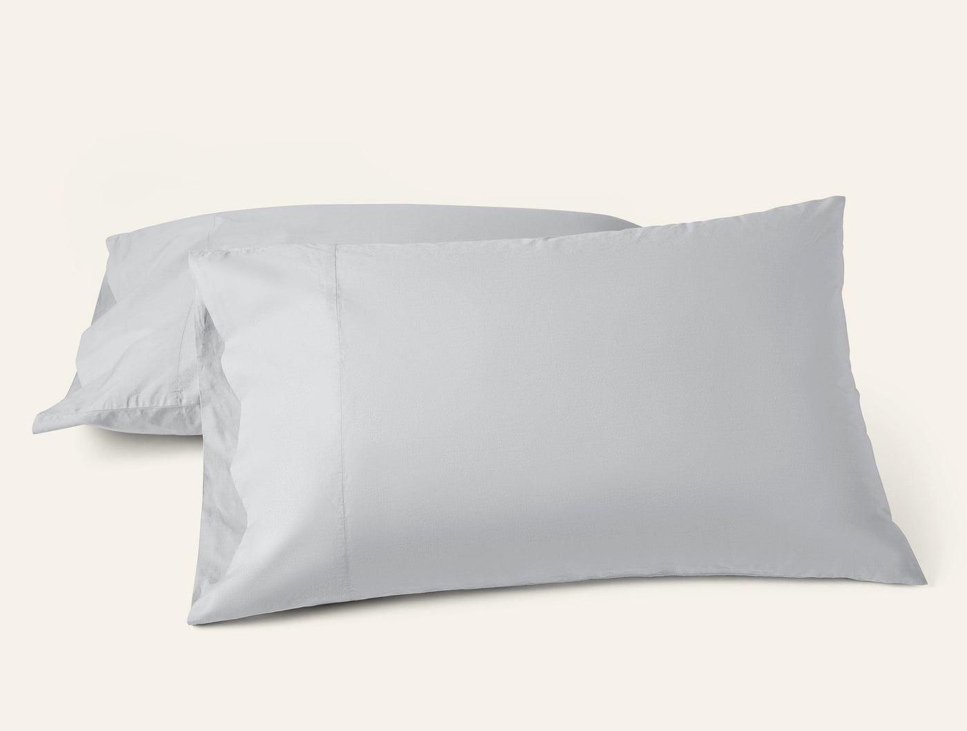 Two Coyuchi Refined Percale pillowcases in silver-grey, stacked and styled against white background.