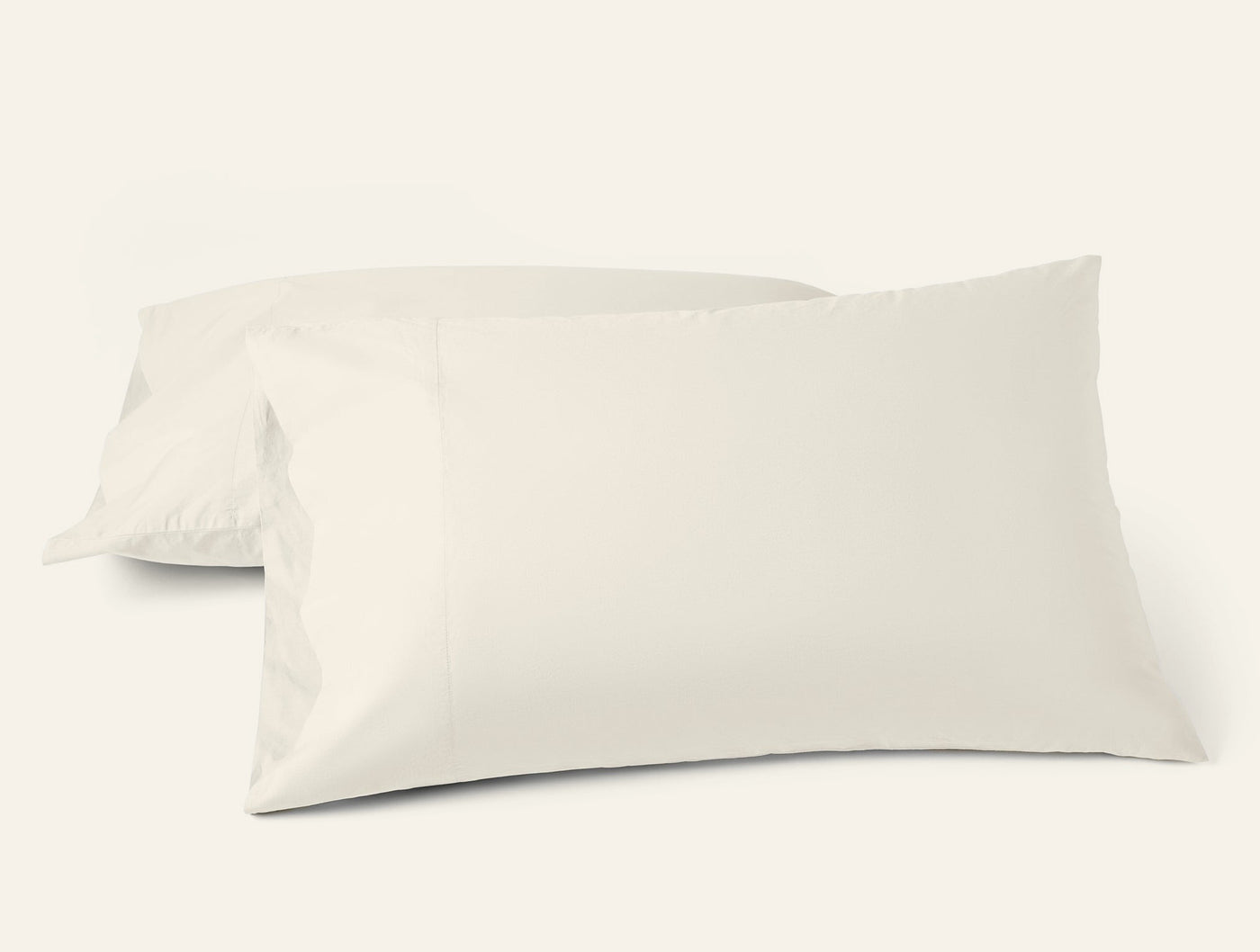 Two ivory Coyuchi Refined Percale pillowcases, crisp and smooth on white background.