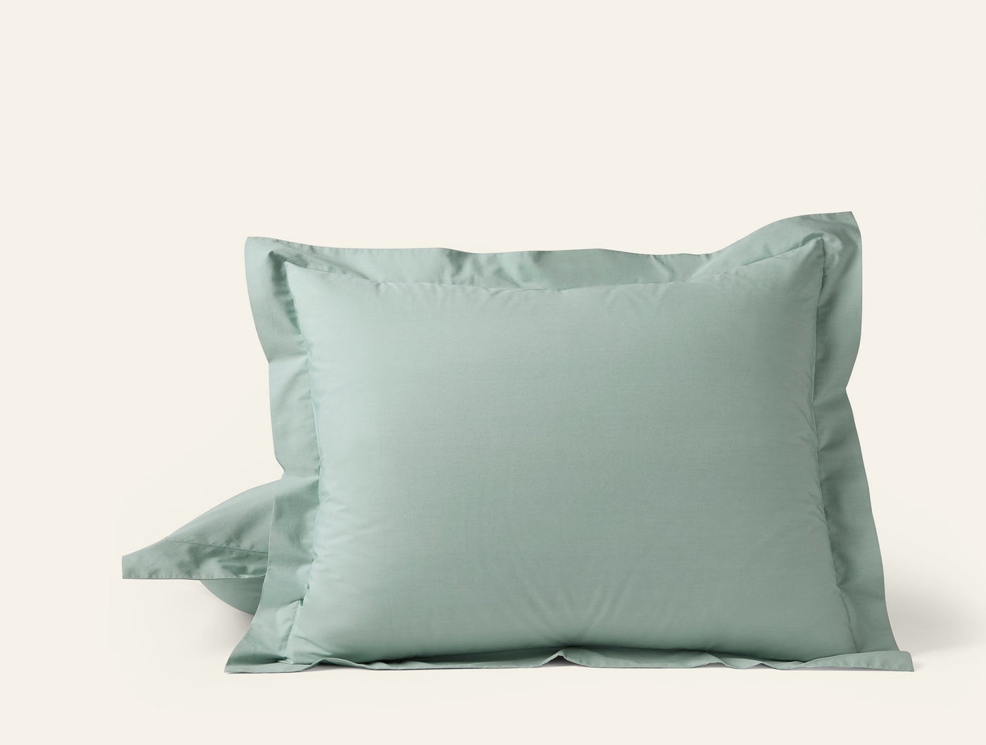 Sage green Coyuchi Refined Percale pillow sham pair with tailored flange detail.