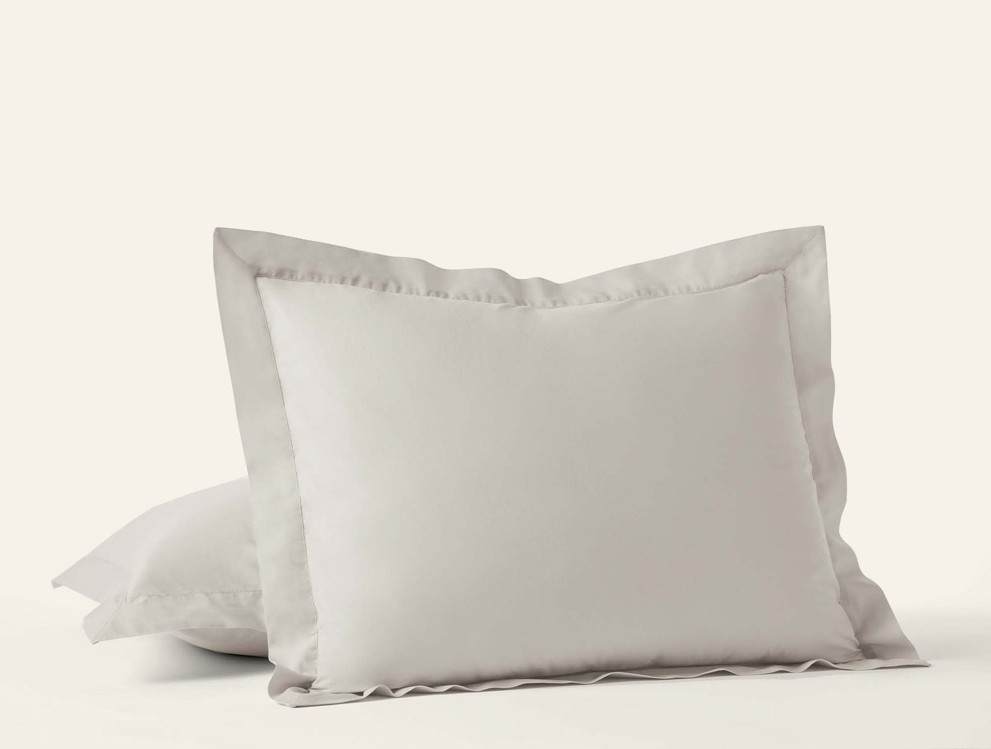 Close-up of Coyuchi Refined Percale shams in ivory with ruffled border detail.