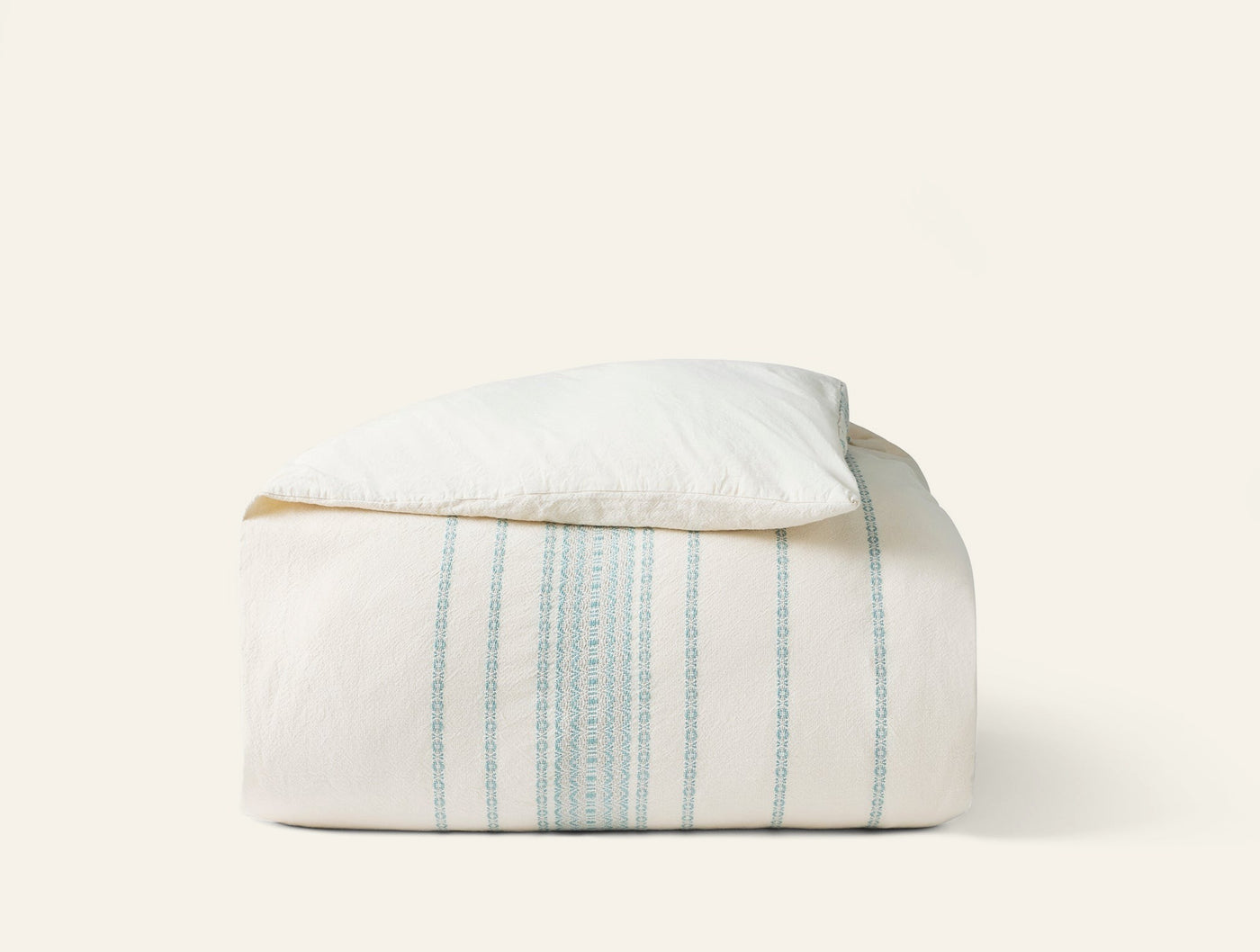 Coyuchi Rippled Stripe duvet cover folded, ivory with sage green vertical stripes.