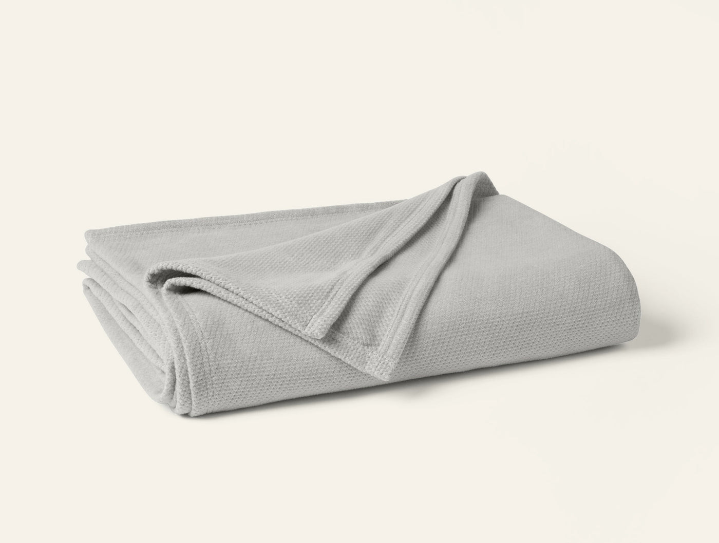 Coyuchi Sequoia blanket folded, showing silver grey waffle-weave texture and trim detail.