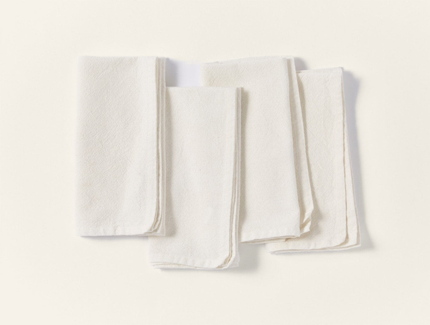 Coyuchi Sonoma Textured napkin set of four in ivory linen, folded flat on white surface.