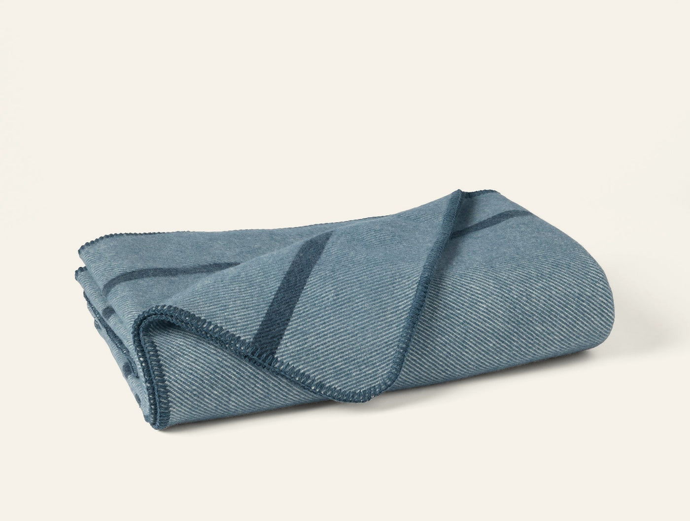 Coyuchi Tahoe Wool Throw in slate blue with navy stripe detail, folded flat.