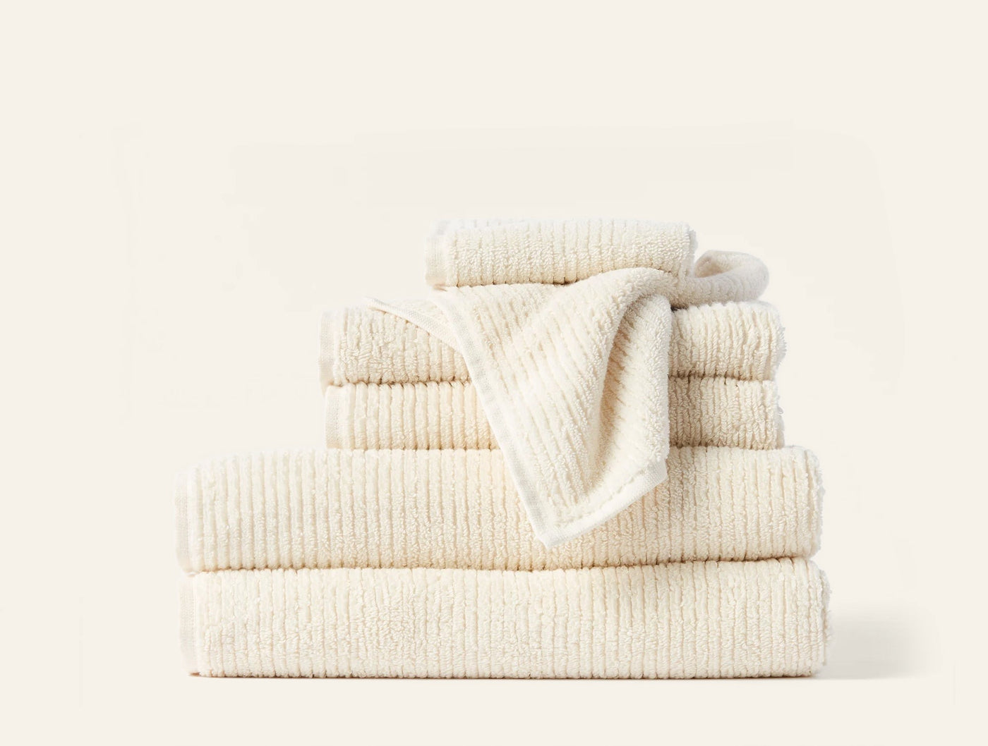 Close-up of Coyuchi Temescal Ribbed towel set in ivory, showing ribbed texture across stacked pieces.