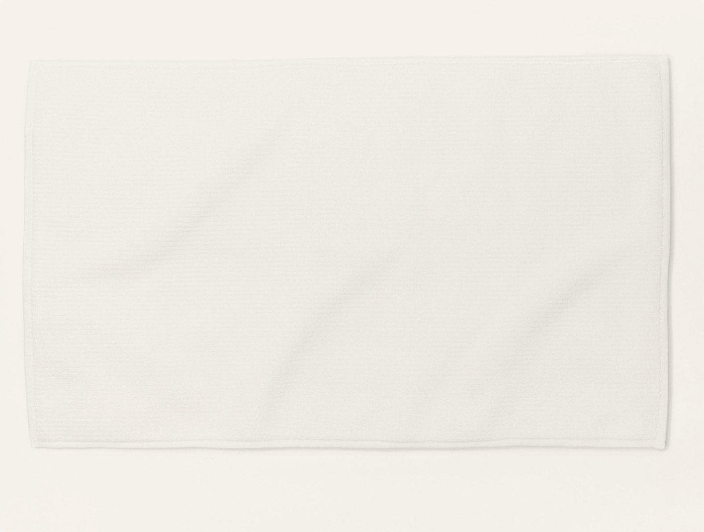 Coyuchi Temescal Ribbed bath rug in white, flat lay view on white background.