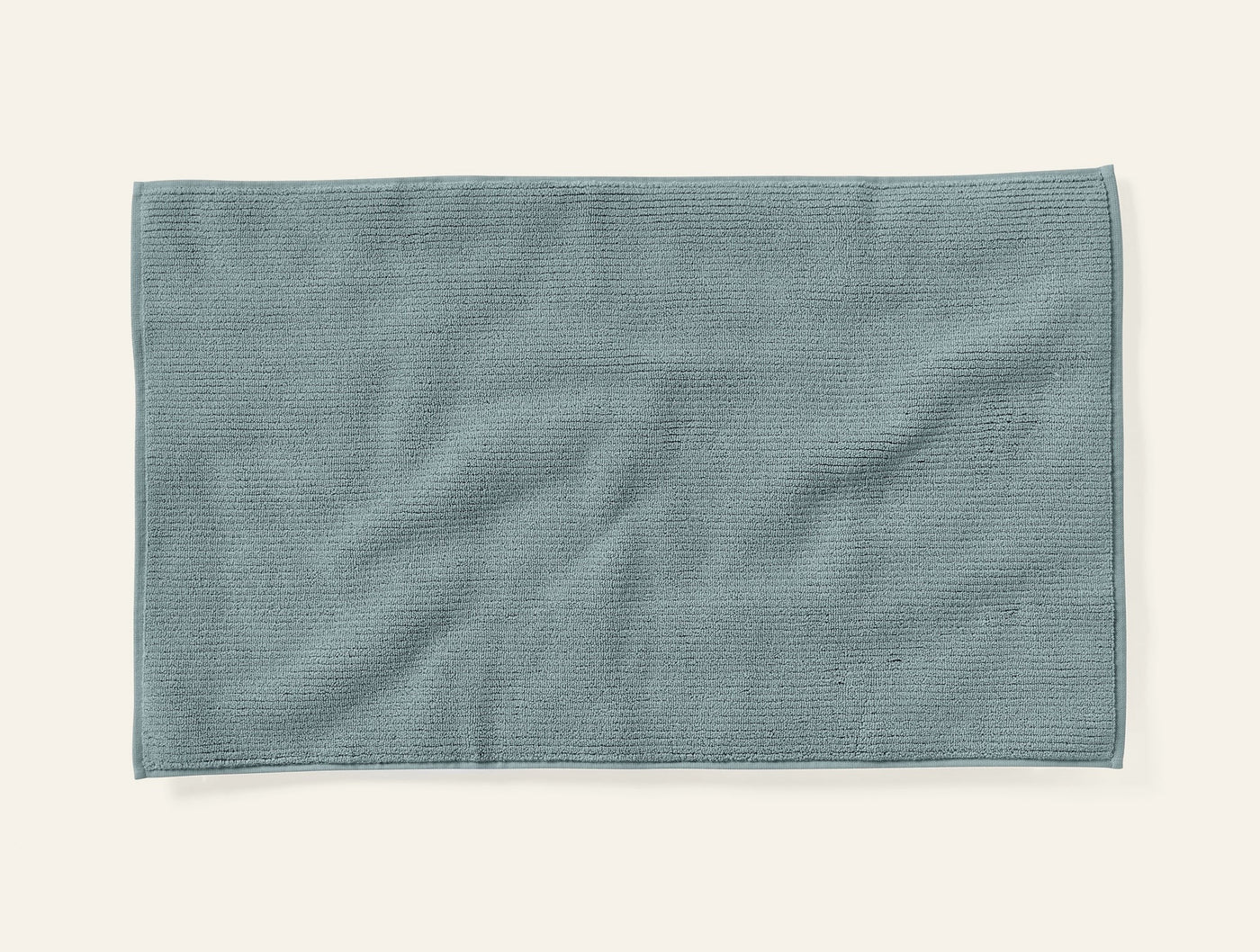 Coyuchi Temescal bath rug in slate blue, textured ribbed weave, flat lay view.
