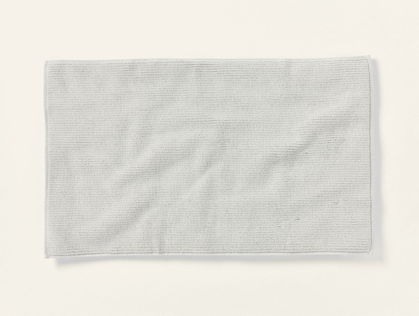 Coyuchi Temescal Ribbed bath rug in ivory, showing subtle rib texture and soft drape.