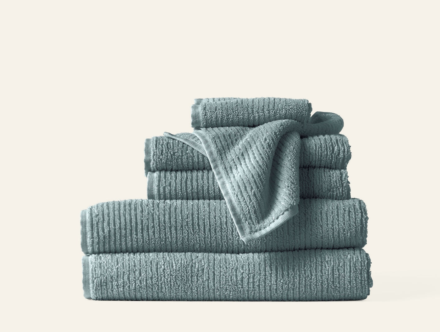 Close-up of stacked slate blue Coyuchi Temescal ribbed terry towels in varying sizes.