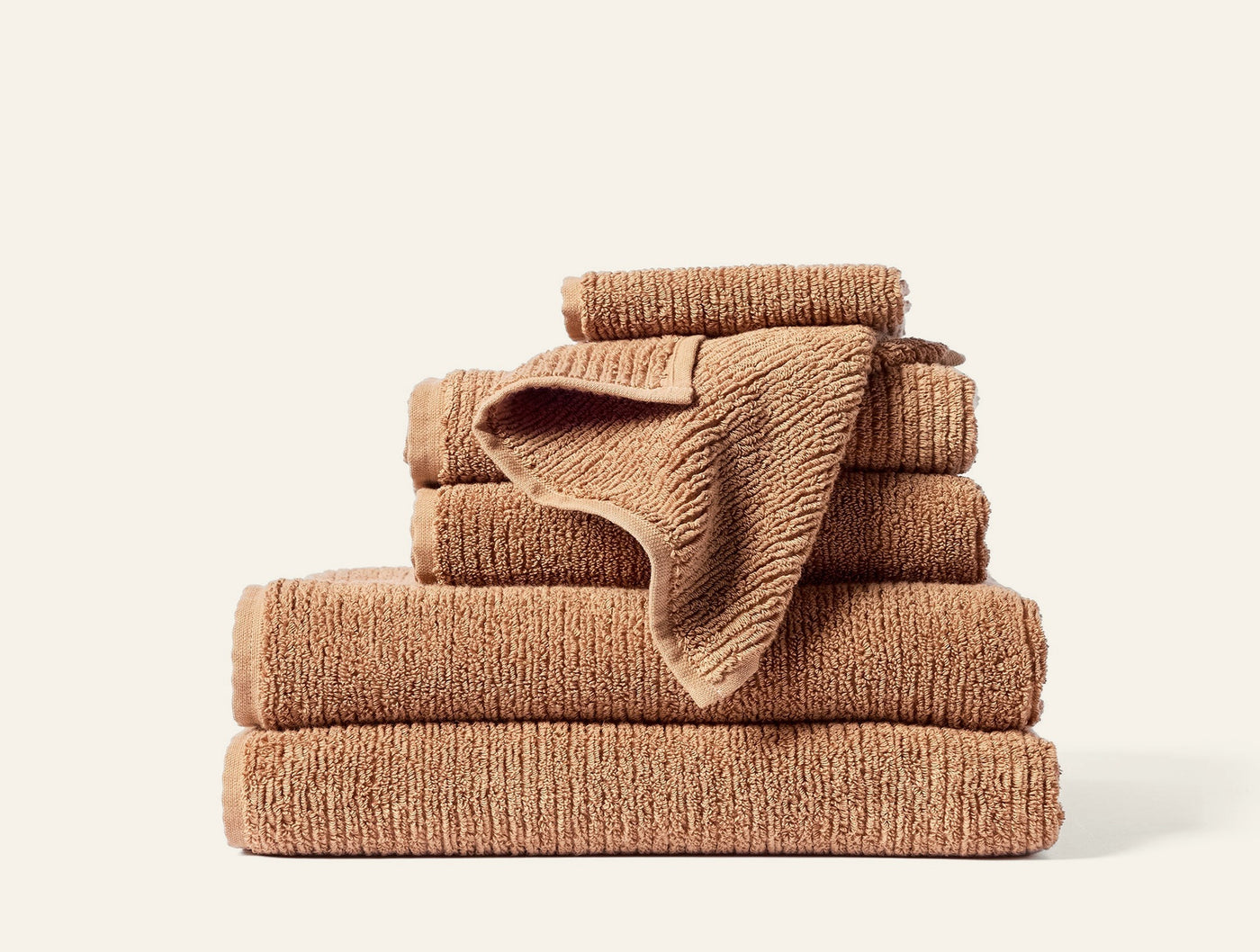 Coyuchi Temescal Ribbed towels stacked in caramel, showing ribbed texture and varied sizes.