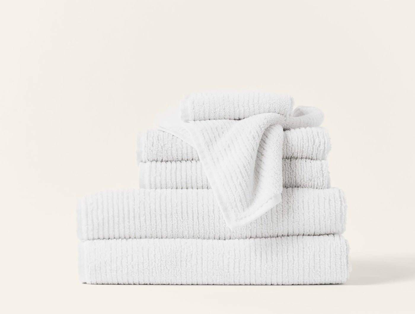 Coyuchi Temescal Ribbed wash cloth in white, stacked towel set with ribbed texture detail.