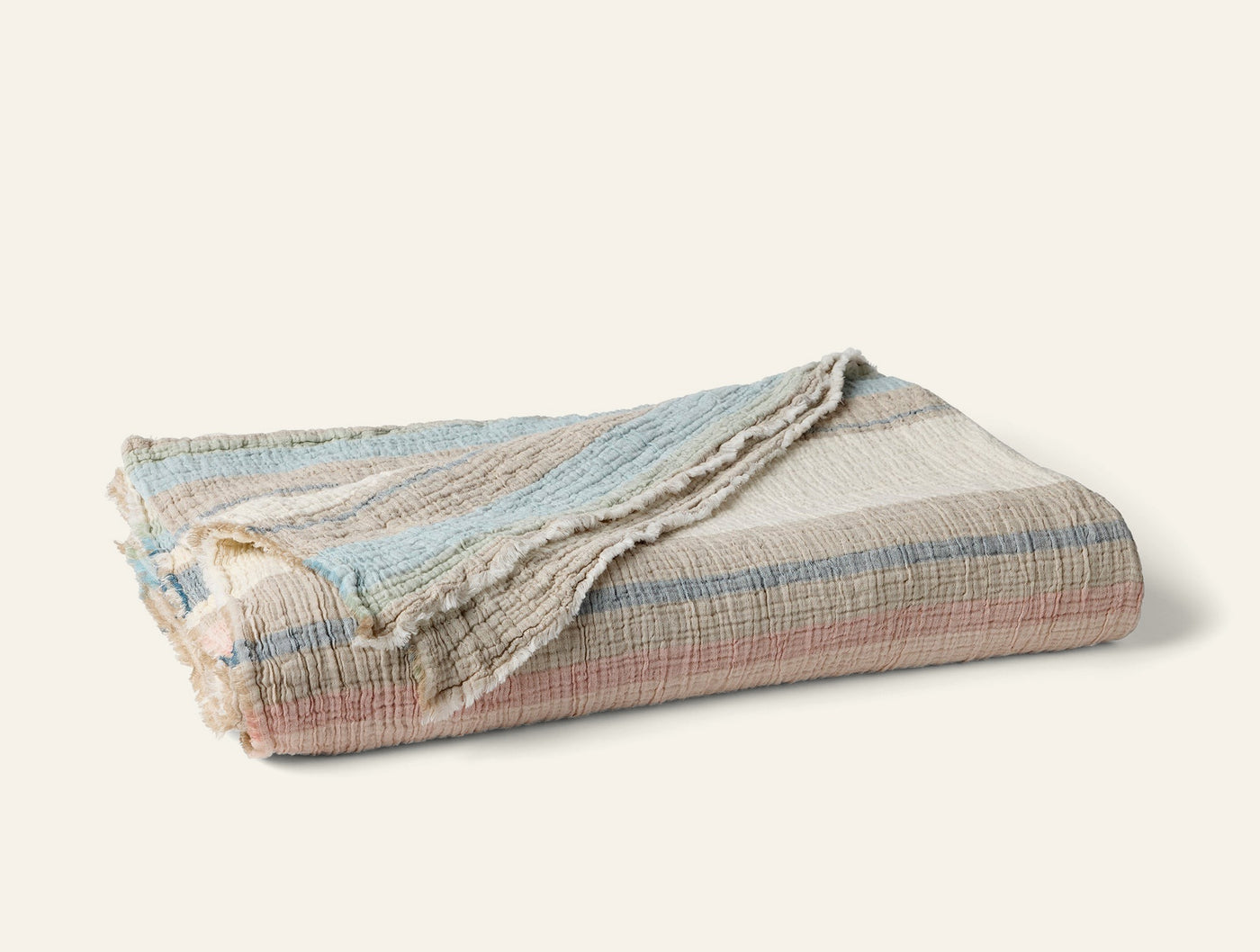 Coyuchi Topanga Matelasse blanket folded, multicolor stripe in blush, blue, and ivory.