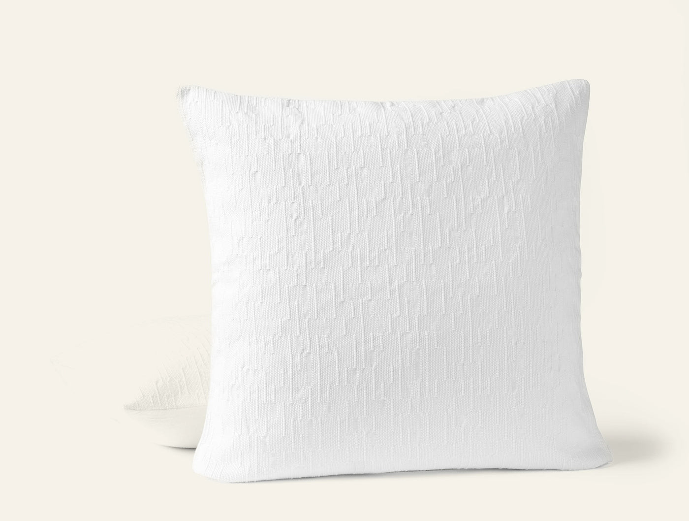 Close-up of Coyuchi Toro Canyon pillow in white with textured woven surface, two pillows stacked.