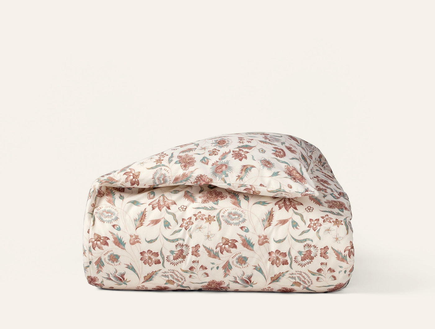 Coyuchi Viola Print duvet cover folded, ivory with red and sage floral pattern.