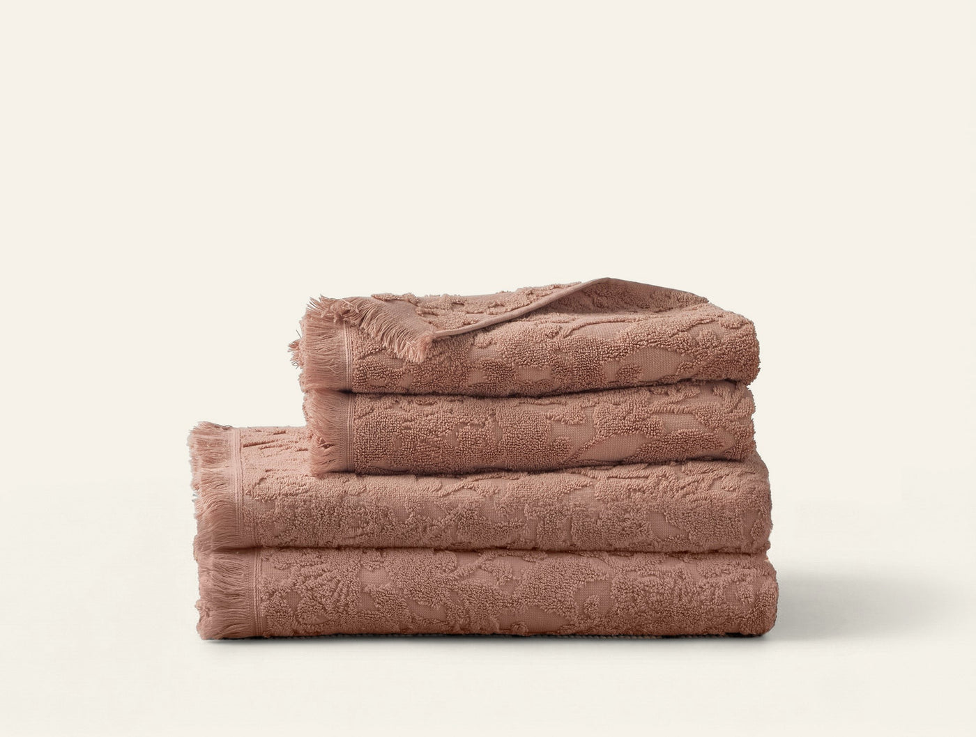 Coyuchi Wildflower bath towel set stacked in dusty rose textured terry cloth.