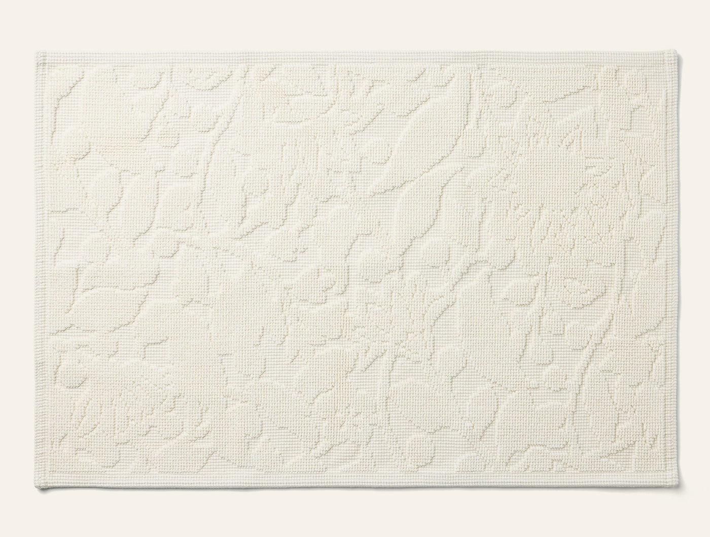 Close-up of Coyuchi Wildflower table runner in ivory with raised floral jacquard texture.