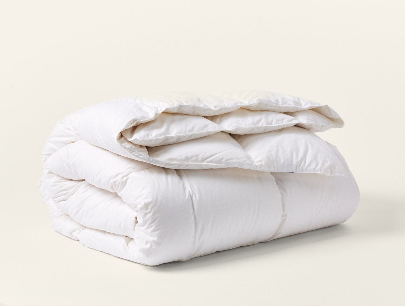 Coyuchi Winter Weight Down duvet insert, white, neatly folded showing plush loft.