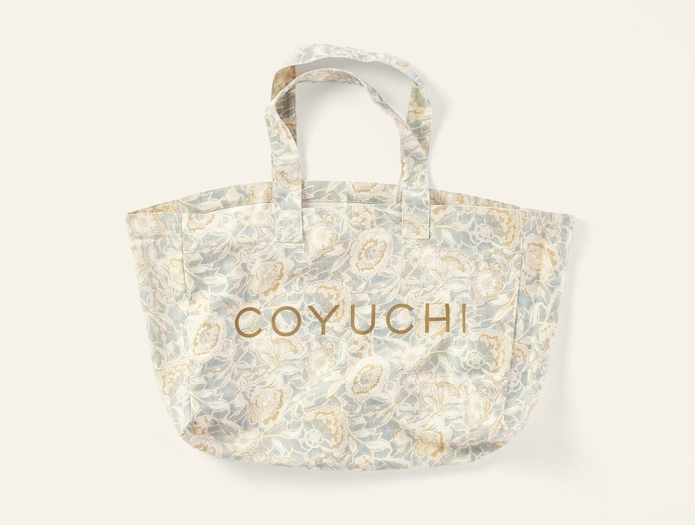Coyuchi Balboa Print tote bag in sage and ivory floral pattern with gold embroidered logo.