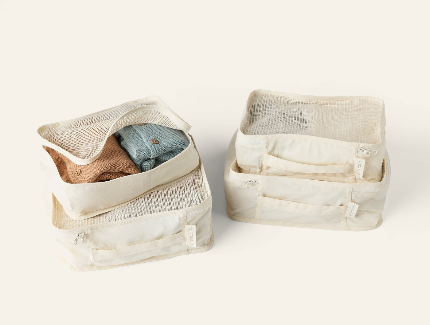 Coyuchi Conserve packing cube set of four in ivory organic cotton with mesh panels.