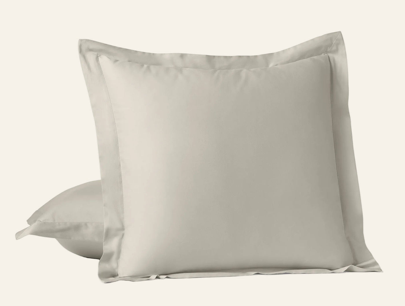 Close-up of Coyuchi Cloud Soft Sateen sham pair in warm linen, flange border detail visible.